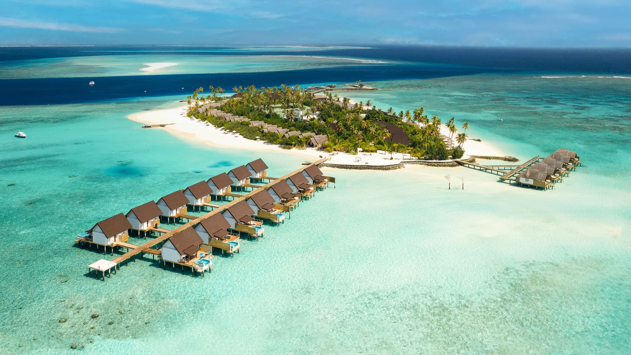 Aerial view of Fushifaru Maldives, rows of overwater villas stretching into the lagoon